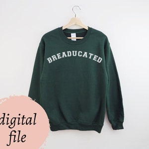Può includere: Una felpa verde scuro con la scritta "BREADUCATED" in lettere bianche.