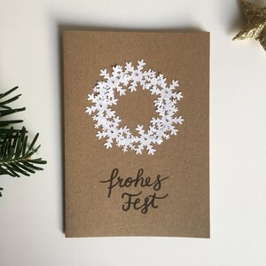 Handgemachte Weihnachtskarte Schneeflockenkranz auf braunem Kraftpapier
