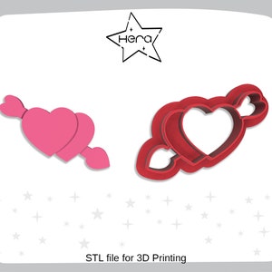 Könnte beinhalten: Zwei 3D-gedruckte Ausstecher in Form eines Pfeils mit Herzen. Der Ausstecher links ist rosa und der rechts ist rot.