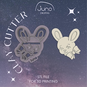 Può includere: Due file STL stampati in 3D per un tagliapasta a forma di coniglio. Il coniglio ha un fiocco e è di colore grigio chiaro. Il testo "CLAY CUTTER" è in un carattere grande e ruotato di 90 gradi. Il testo "STL FILE FOR 3D PRINTING" è in un carattere più piccolo.