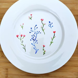 Jolie assiette ou plat , en porcelaine blanche, peint à la main.
