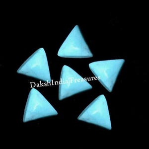 May include: Six turquoise triangle cabochons, each with a smooth, polished surface. The cabochons are arranged in a star shape on a black background.