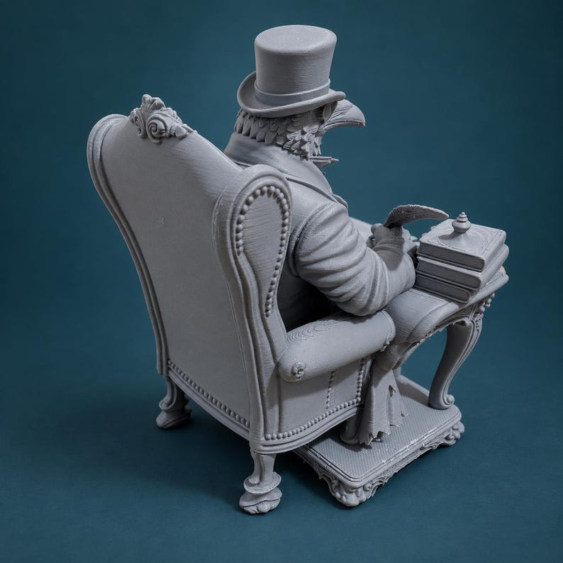 May include: A monochromatic grey 3D printed figurine of a bird-headed figure wearing a top hat and formal attire. The figure is seated in a tufted armchair at a small desk, holding a quill pen and resting a hand on a stack of books on the desk surface.