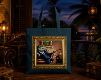 May include: A dark teal tote bag featuring a central rectangular print of an alligator wearing a blue suit and red tie, seated in a chair while holding a pipe. The print is enclosed within a detailed, ornate gold-colored picture frame.