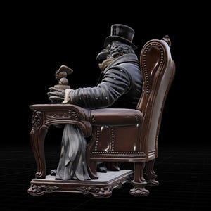 May include: A figurine of an anthropomorphic raven wearing a black top hat and a dark coat, seated in a brown tufted armchair. The raven figure rests its hands on a small wooden side table, holding a small object while sitting on a decorative base.