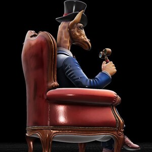 May include: A whimsical sculpture of a giraffe with a human body, wearing a blue suit, top hat, and holding binoculars. The giraffe is seated in a red, ornate armchair with gold trim, set against a black background.