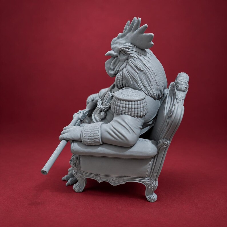 May include: A gray resin figurine of an anthropomorphic rooster dressed in a military-style uniform with epaulets and medals, sitting in an ornate armchair while holding a long, thin staff or weapon in its hand, captured from a side profile view.