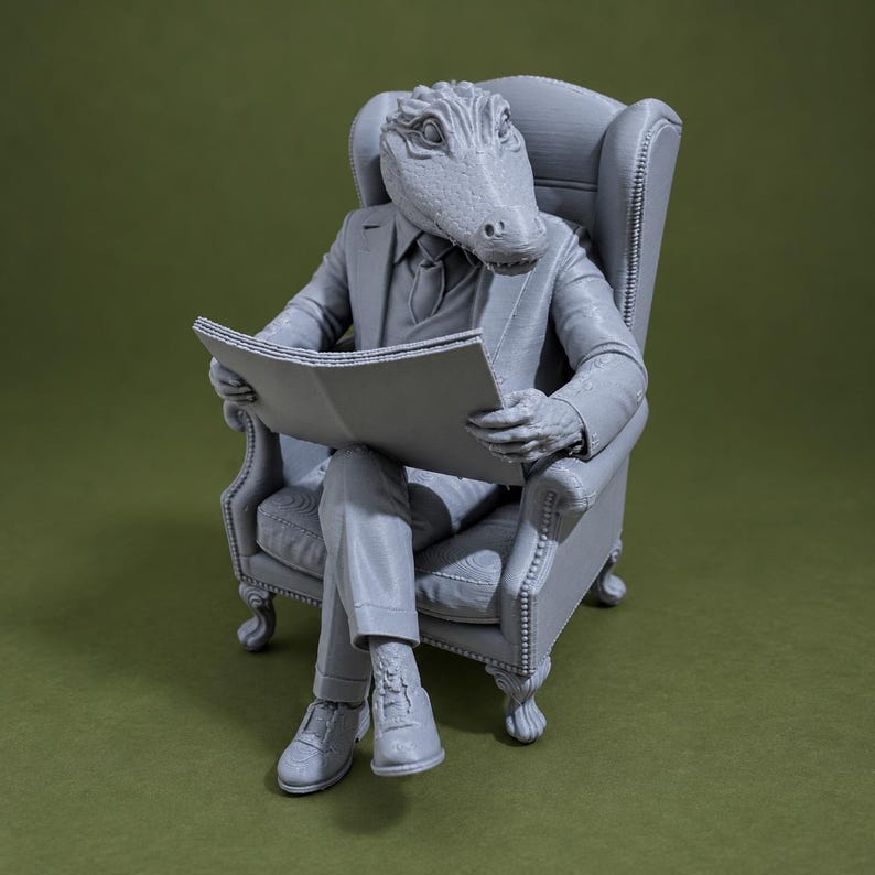 May include: A monochromatic gray 3D printed figurine of an anthropomorphic alligator wearing a formal suit and tie, seated in a high-backed wingback chair while holding an open newspaper. The figure has textured skin and is posed with legs crossed.