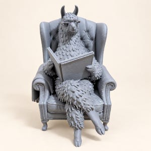 K&ouml;nnte beinhalten: Eine einfarbige graue Lama-Figur mit Brille, die in einem gepolsterten Ohrensessel sitzt und ein offenes Buch h&auml;lt. Das Lama hat ein strukturiertes Fell und sitzt mit &uuml;berkreuzten Beinen in dem Sessel, der mit Knopfdetails verziert ist.