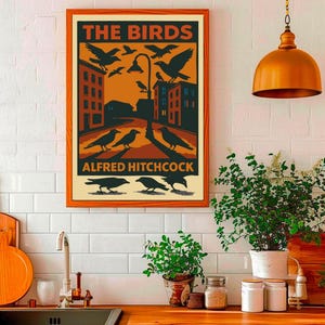 May include: A vintage-style poster with an orange background featuring the title "THE BIRDS" in black text. The poster depicts a city street with black birds flying and perched on a street lamp. The text "ALFRED HITCHCOCK" appears at the bottom of the poster.