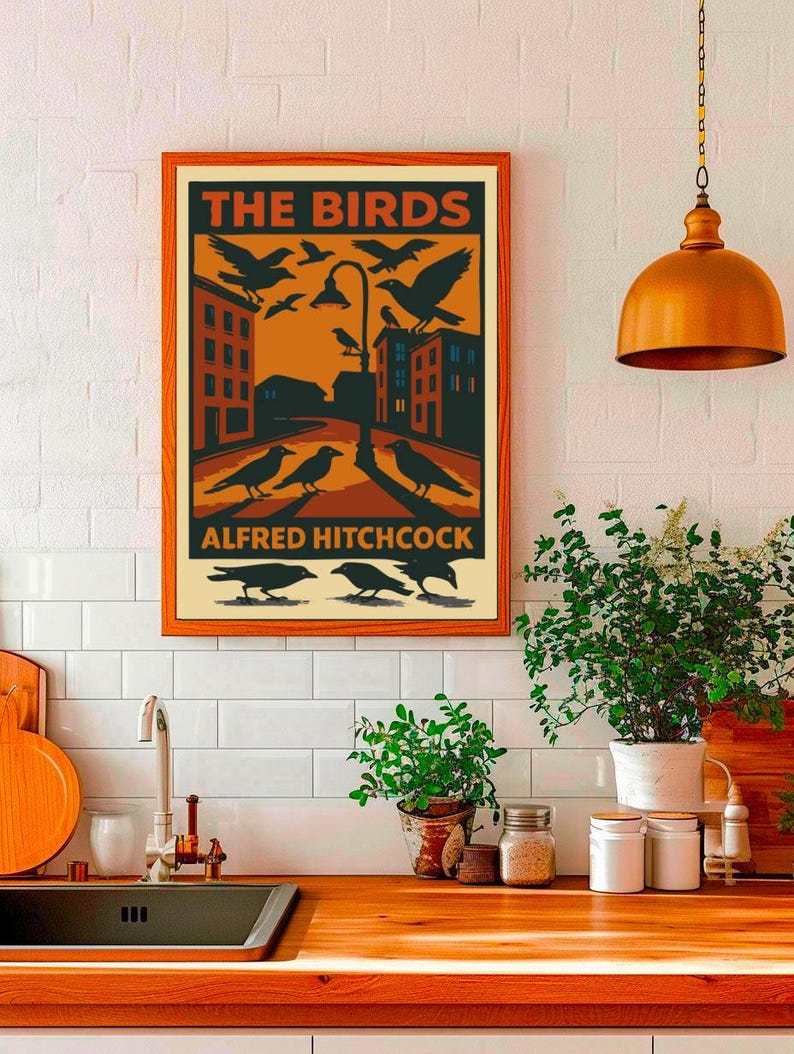 May include: A vintage-style poster with an orange background featuring the title "THE BIRDS" in black text. The poster depicts a city street with black birds flying and perched on a street lamp. The text "ALFRED HITCHCOCK" appears at the bottom of the poster.