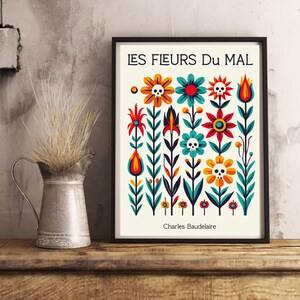 May include: A black framed print with a white background featuring a colorful floral design with skulls. The text "LES FLEURS DU MAL" is at the top of the print and "Charles Baudelaire" is at the bottom.