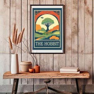 K&ouml;nnte beinhalten: Ein Vintage-Poster f&uuml;r "Der Hobbit" von J.R.R. Tolkien. Das Poster zeigt eine farbenfrohe Illustration eines gro&szlig;en Baumes mit einem Hobbit-Loch an seiner Basis, umgeben von sanften H&uuml;geln und einem gewundenen Pfad. Der Text "THE HOBBIT" ist in fetten, wei&szlig;en Buchstaben am unteren Rand des Posters gedruckt.