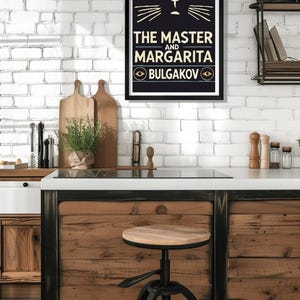 May include: A black and gold framed poster featuring a black cat illustration and the text "THE MASTER AND MARGARITA BULGAKOV" in gold lettering.