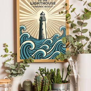 May include: A framed print of a lighthouse with waves crashing around it. The print has the title "To the Lighthouse - Virginia Woolf -" at the top. The print is surrounded by plants and a camera.