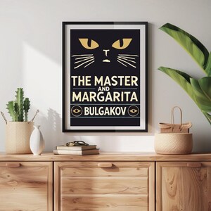 May include: Black and white poster featuring a stylised illustration of a cat's face. The text reads "The Master and Margarita" with "Bulgakov" below in a circle with a stylised eye on each side.