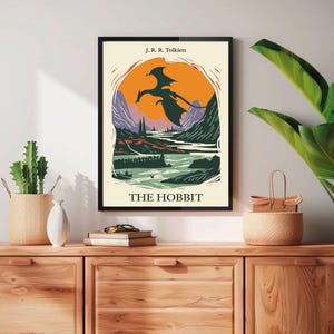 May include: A vintage-style poster for "The Hobbit" by J.R.R. Tolkien. The poster features a black silhouette of a dragon flying over a landscape with mountains, a river, and a sunset.