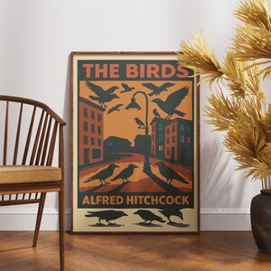 May include: A vintage-style poster with a red, orange, and black color scheme. The poster features the text "THE BIRDS" and "ALFRED HITCHCOCK" with an illustration of a city street and birds flying overhead.