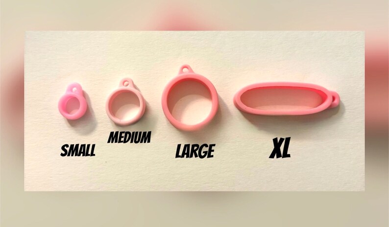May include: Four pink silicone rings in different sizes: small, medium, large, and extra large. The rings are labelled with their sizes.