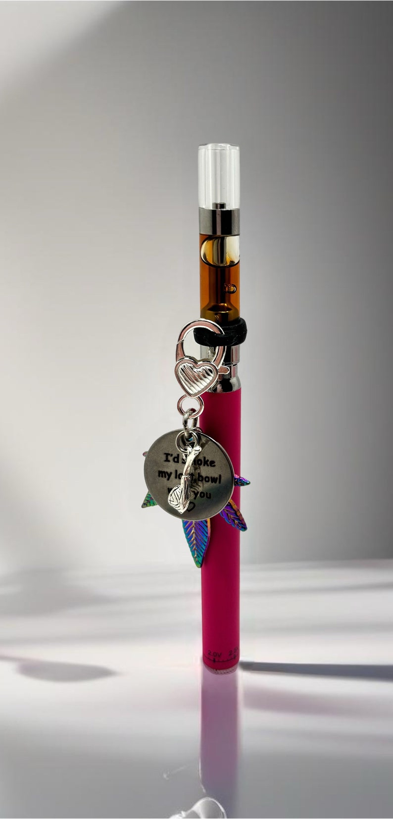 May include: A pink vape pen with a silver charm that says "I'd smoke my last bowl with you". The charm has a small heart and a leaf design.