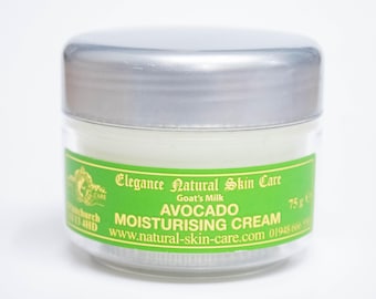 May include: A green and white jar of avocado moisturizing cream with a silver lid. The jar is labeled "Elegance Natural Skin Care Goat's Milk Avocado Moisturizing Cream 75g e www.natural-skin-care.com 01948 666 444"