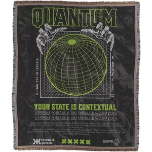 Op de afbeelding: Een zwart en groen geweven wandkleed met het woord "QUANTUM" in grote witte letters. Het wandkleed heeft een groene gerasterde globe omringd door skeletachtige handen. De tekst "YOUR STATE IS CONTEXTUAL" staat in witte letters onder de globe. Het wandkleed bevat ook de tekst "YOUR STATE IS CONTEXTUAL YOUR STATE IS IN COMMUNICATION" in kleinere witte letters.