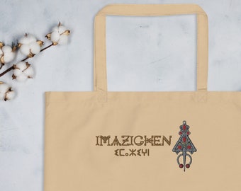 May include: A beige tote bag with a brown embroidered design featuring the text "IMAZIGHEN" and a stylized symbol with red accents.