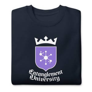 Op de afbeelding: Marineblauw sweatshirt met ronde hals. Het heeft een witte kroon boven een paars schild met een moleculair ontwerp. De tekst "Entanglement University" staat eronder in een gestileerd lettertype.