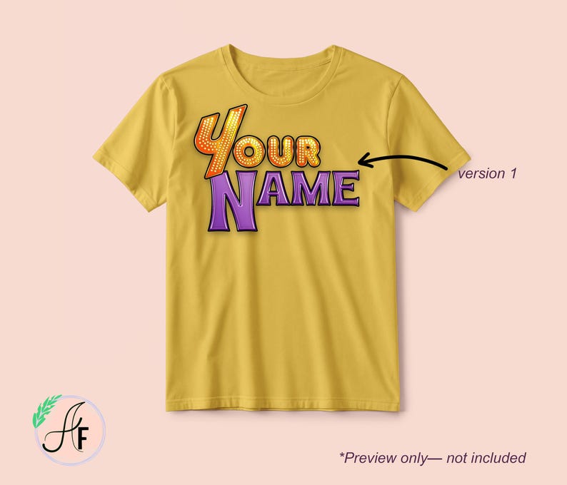 Op de afbeelding: Een mosterdgeel t-shirt met korte mouwen en de tekst "YOUR NAME" in een gestileerd lettertype. Het woord "YOUR" is oranje met een stippenpatroon en "NAME" is paars. Een zwarte pijl wijst naar de tekst met het label "version 1".