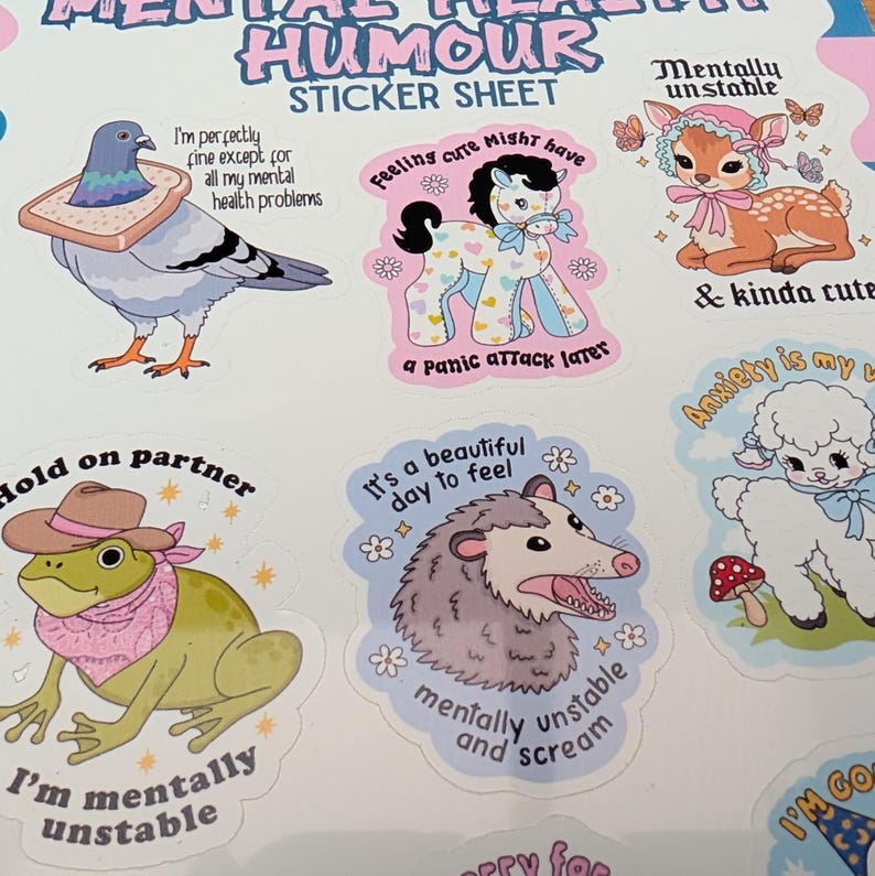 May include: A sticker sheet titled Mental Health Humour Sticker Sheet featuring six illustrations: a pigeon with bread, a pony, a fawn, a frog in a cowboy hat, an opossum, and a lamb, each paired with humorous text about mental health.