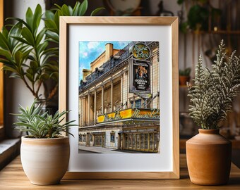 May include: A framed print of the Music Box Theatre, featuring a marquee and a poster for "Dorian Gray." The building has a classical facade with columns and a yellow marquee. The print is in a light wooden frame.