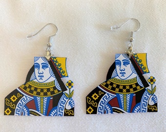 May include: A pair of earrings featuring the Queen of Hearts playing card design. The earrings are made of metal and have a silver hook fastening. The Queen of Hearts is depicted in a traditional playing card style, with a red and black suit and a yellow crown.