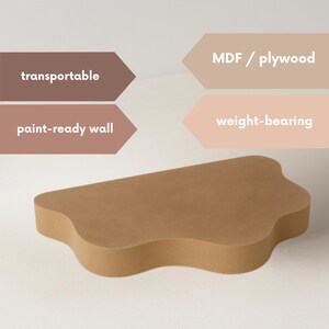Op de afbeelding: Bruin, golvend MDF/multiplex wandrek. Het rek is overschilderbaar, transporteerbaar en draagkrachtig. Tekst op de afbeelding geeft aan dat het rek van MDF/multiplex is. Ontworpen voor wandmontage.