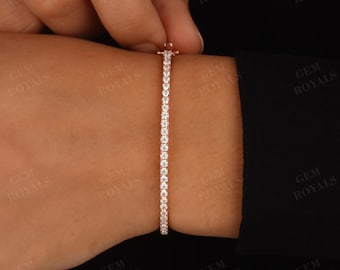 以下が含まれることがあります： ローズゴールドのバンドにきらめくダイヤモンドが並んだ、繊細なテニスブレスレットです。