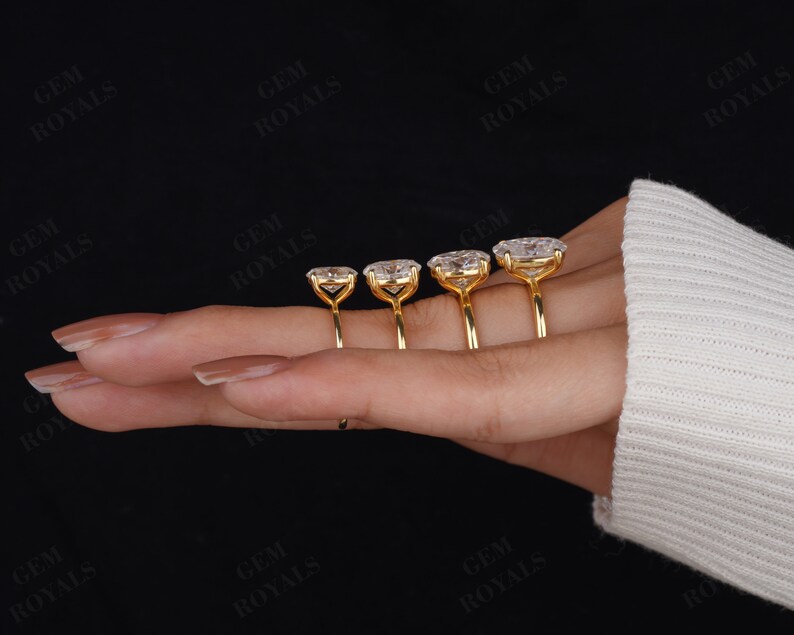 Pode incluir: Quatro an&eacute;is de ouro com diamantes de forma oval engastados em garras. Os an&eacute;is est&atilde;o dispostos em uma fila em uma m&atilde;o, com o anel maior &agrave; esquerda e o anel menor &agrave; direita.