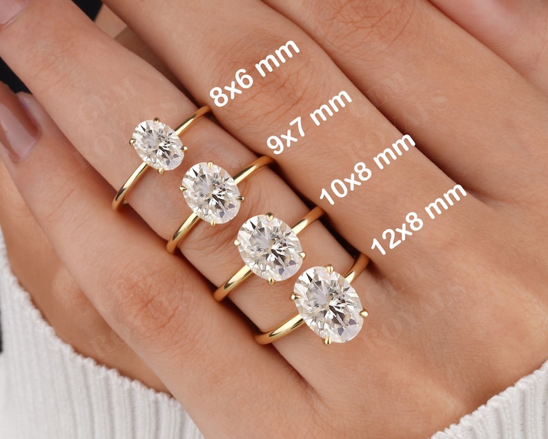 Pode incluir: Quatro an&eacute;is de ouro com diamantes de forma oval de diferentes tamanhos. Os an&eacute;is s&atilde;o etiquetados com suas dimens&otilde;es em mil&iacute;metros: 8x6 mm, 9x7 mm, 10x8 mm e 12x8 mm.