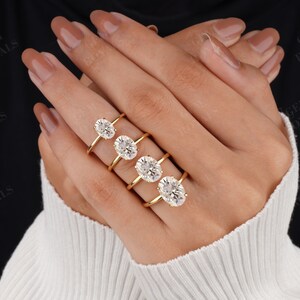 Pode incluir: Quatro an&eacute;is de ouro com diamantes de forma oval de diferentes tamanhos. Os an&eacute;is est&atilde;o empilhados em um dedo.