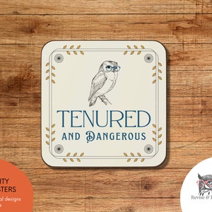 May include: A white ceramic coaster with a brown owl wearing blue glasses. The coaster has a gold border and the text "TENURED AND DANGEROUS" in blue.
