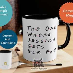 May include: White ceramic mug with a black rim and handle. The mug has the text "THE ONE WHERE JESSICA GETS HER PHD" printed on it in black with colorful dots. The mug is on a wooden surface. The text "Ceramic Mug" is in a red starburst shape in the upper right corner of the image.