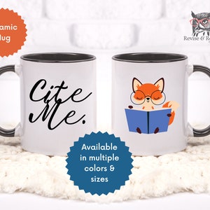 May include: White ceramic mug with a black rim and handle. The mug has the text "Cite Me." in black cursive writing on the front.  The mug is available in multiple colors and sizes.