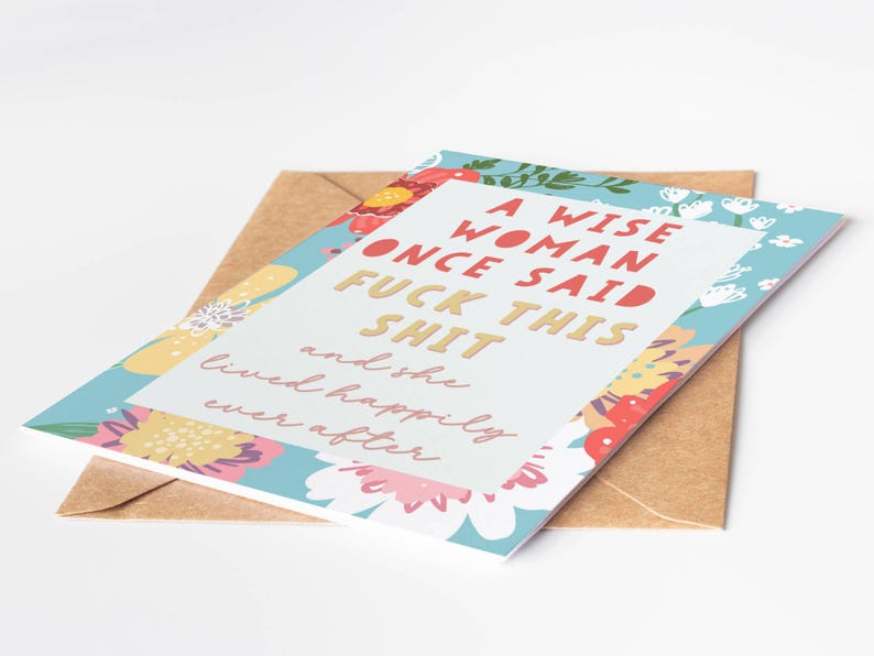May include: Greeting card with a floral border and the text "A WISE WOMAN ONCE SAID FUCK THIS SHIT and she lived happily ever after." The card is on top of a brown envelope.