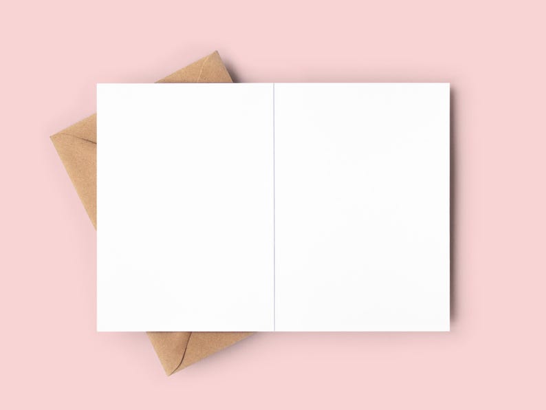 May include: A blank white card with a brown envelope. The card is folded in half and the envelope is partially covering the card.