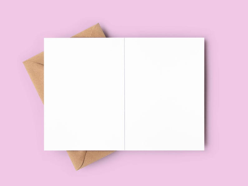 May include: An open, blank white greeting card with a brown envelope on a light pink background. The card is centered, with the envelope partially visible beneath it. Ideal for stationery and paper goods.