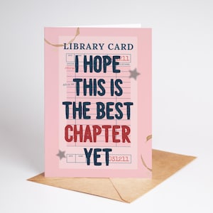 以下が含まれることがあります： 「I HOPE THIS IS THE BEST CHAPTER YET」という言葉が紺色と赤色で書かれたピンク色のグリーティングカード。カードは図書館カードのデザインで、茶色の封筒に入っています。