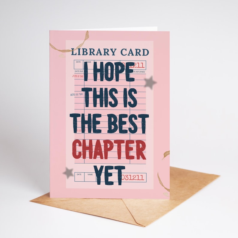 以下が含まれることがあります： 「I HOPE THIS IS THE BEST CHAPTER YET」という言葉が紺色と赤色で書かれたピンク色のグリーティングカード。カードは図書館カードのデザインで、茶色の封筒に入っています。