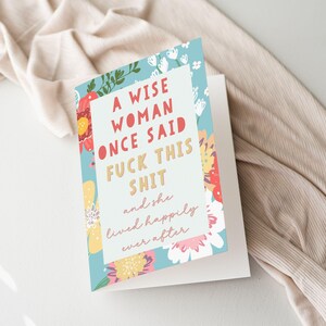May include: Greeting card with a floral design and the text "A wise woman once said fuck this shit and she lived happily ever after." The card has a white background and a blue floral border.