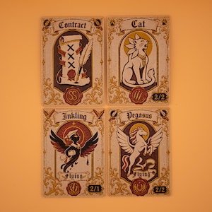 May include: Four fantasy-themed cards with ornate borders and illustrations. The cards feature the words "Contract," "Cat," "Inkling," and "Pegasus." Each card has a unique design, including a quill, a cat, a winged creature, and a winged horse.