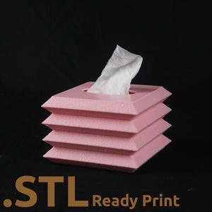 Può includere: Un portatovaglioli rosa geometrico con un design impilabile. I fazzoletti bianchi vengono tirati dall'apertura superiore. Il testo ".STL Ready Print" è stampato nella parte inferiore dell'immagine.