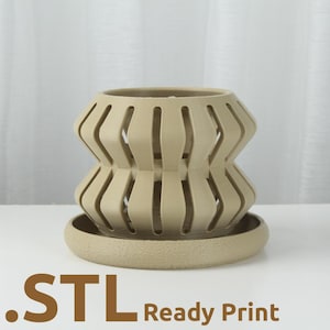 May include: A beige, 3D-printed decorative planter with a geometric design, featuring vertical slots and a matching base. The text ".STL Ready Print" is visible at the bottom. The planter is designed for home decor.
