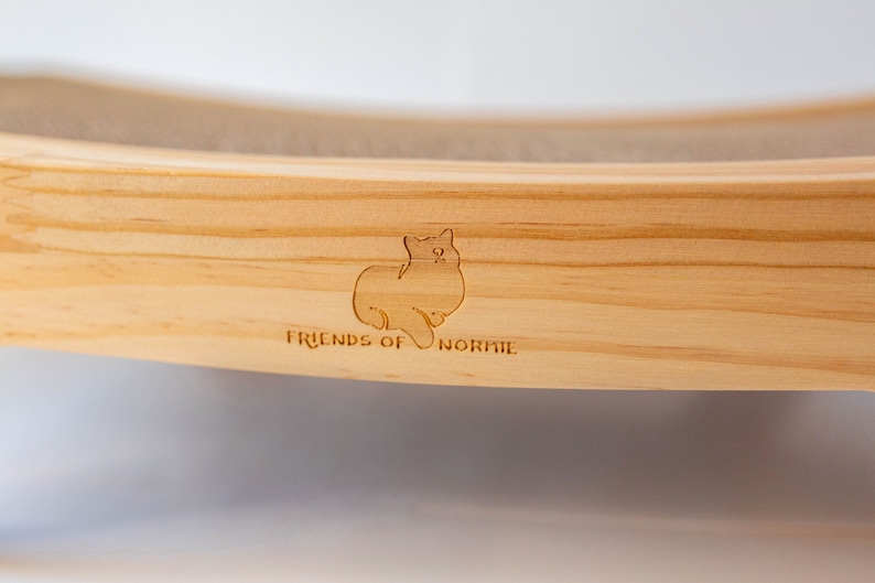 Closeup of the Friends of Normie logo engraved on the cat scratcher